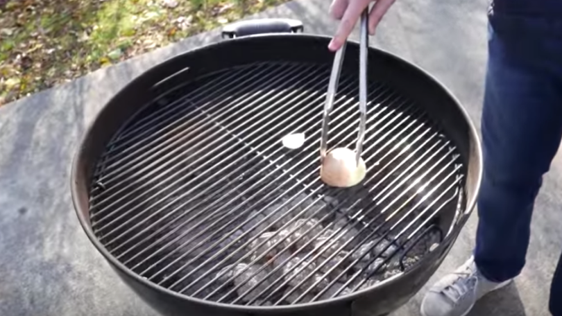Cleaning BBQ grill using a fork and an onion